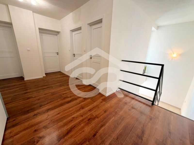 Interior of a family house with a wooden decor floor and white doors.