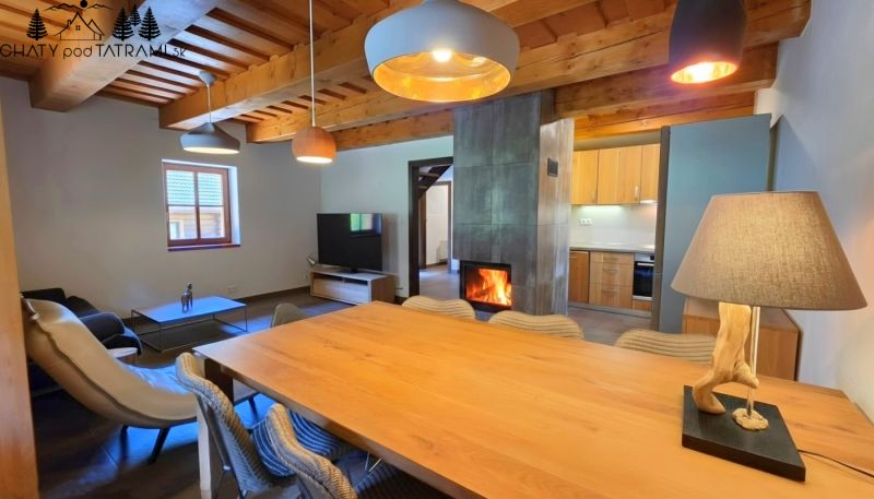 Living space in a cabin with wood-patterned flooring and a fireplace.