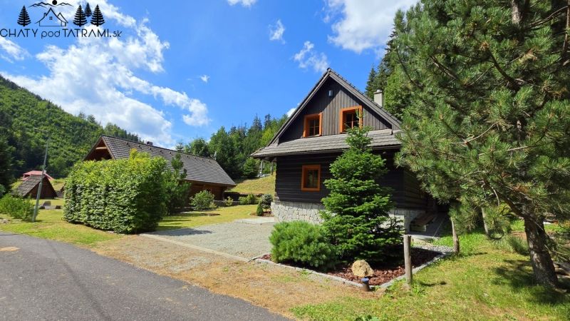 A cottage in Jarabá surrounded by trees and a blue sky in a mountain landscape.