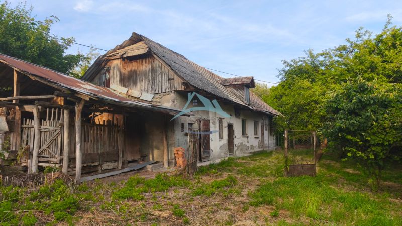 An older family house in the village of Čelovce, surrounded by greenery and wooden annexes.