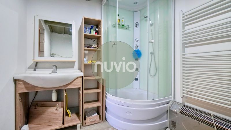 A bathroom in a family house with a corner shower and a sink.