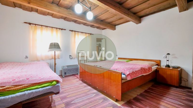 A bedroom in a family house with a wooden ceiling and comfortable beds.
