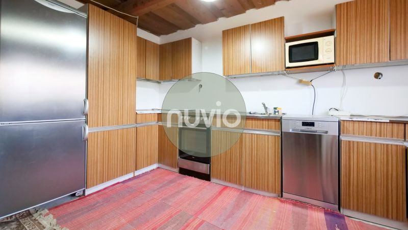 A kitchen in a family house with wooden cabinets and a refrigerator.