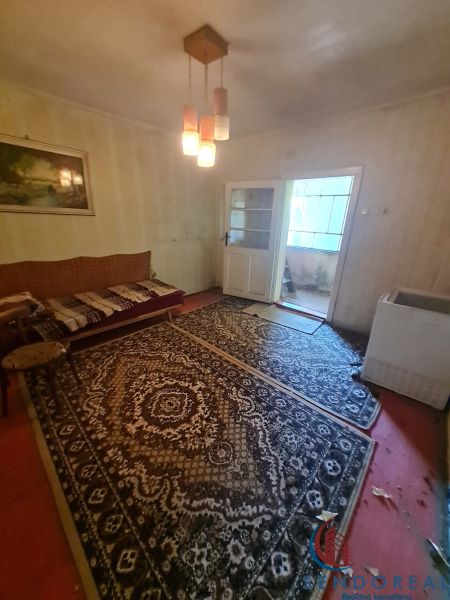 A room in a family house with carpets, lighting, and a sofa.