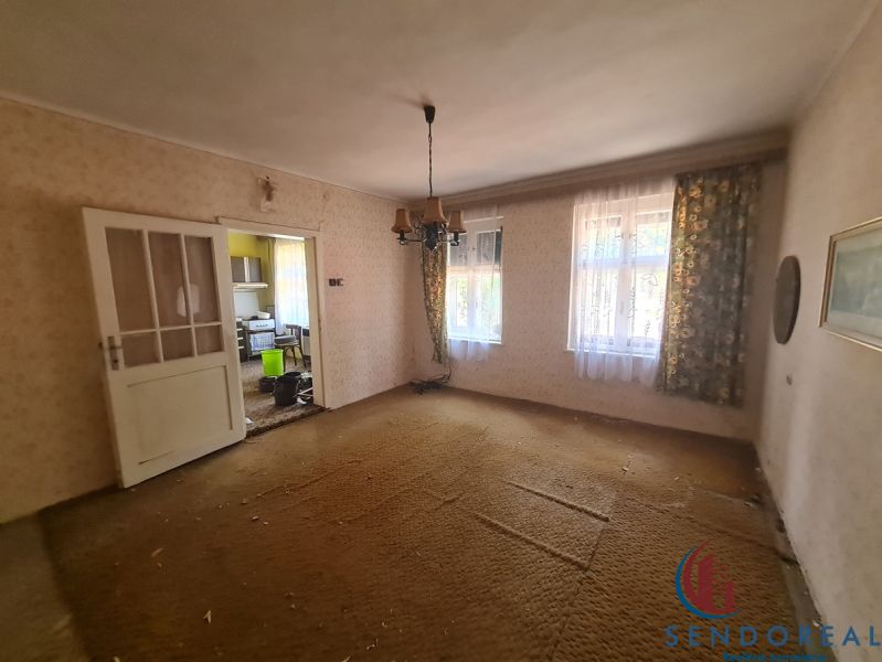Living room in a family house with carpeted floor and antique chandelier.