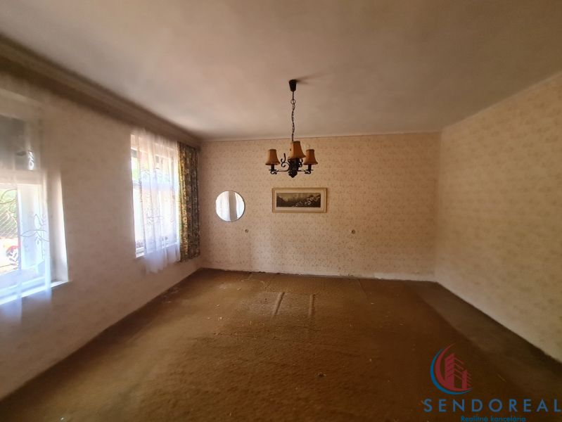 The interior of a family house with carpeted flooring, light, and curtains on the windows.