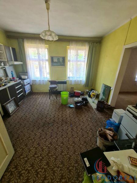Living room with carpet decor, furniture, and plastic buckets in a family house.