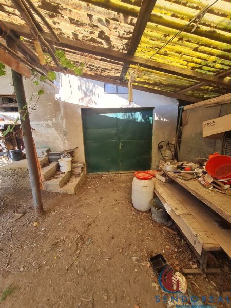 A garage at a family house in Dolné Otrokovce with a metal gate and a shelter.