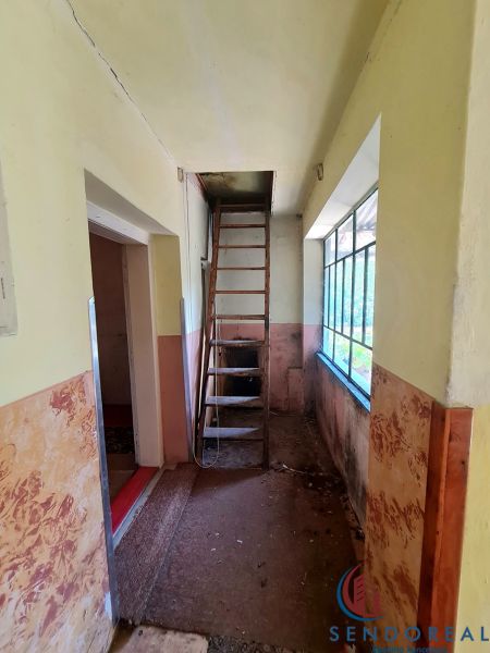 A narrow hallway with a ladder to the attic in a family house.