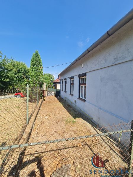 A family house in Dolné Otrokovce with fencing and a driveway in the yard.