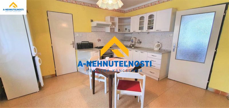 A kitchen in a family house with white cabinets and a dining table.
