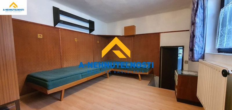 Interior of a family house with a bed and a floor with a wooden decor.