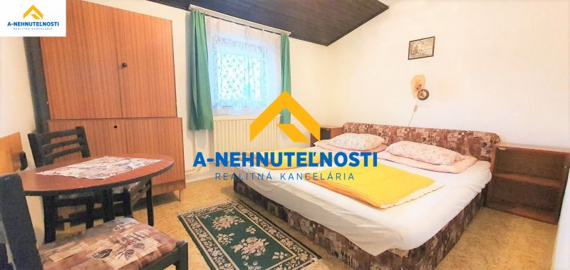 Bedroom in a family house with a carpet, bed, and wooden table.