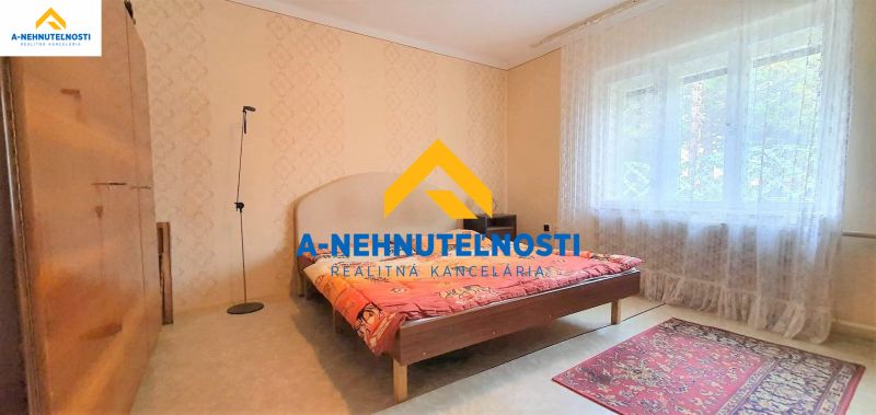 A bedroom in a family house with a red carpet and a large window.