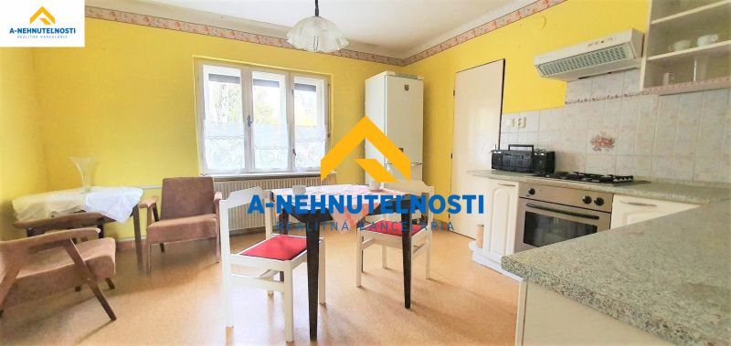 A kitchen in a family house with a wooden decor floor and yellow walls.