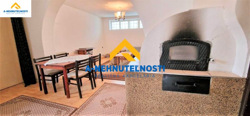 Interior of a family house with a dining table, wooden decor flooring, fireplace.