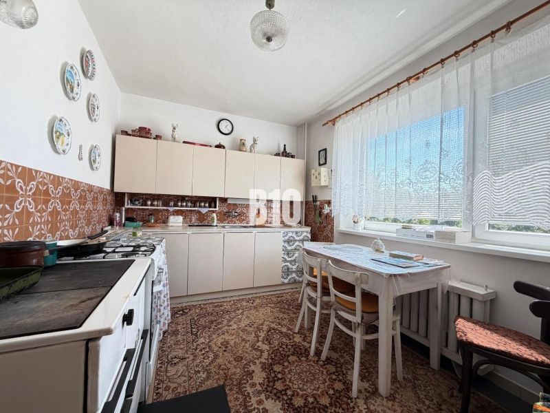 A kitchen in a family house with seating, tiles, and decorative plates on the wall.