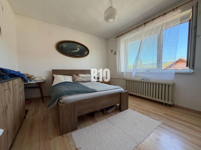 Bedroom with a bed and wooden decor flooring in a family house.