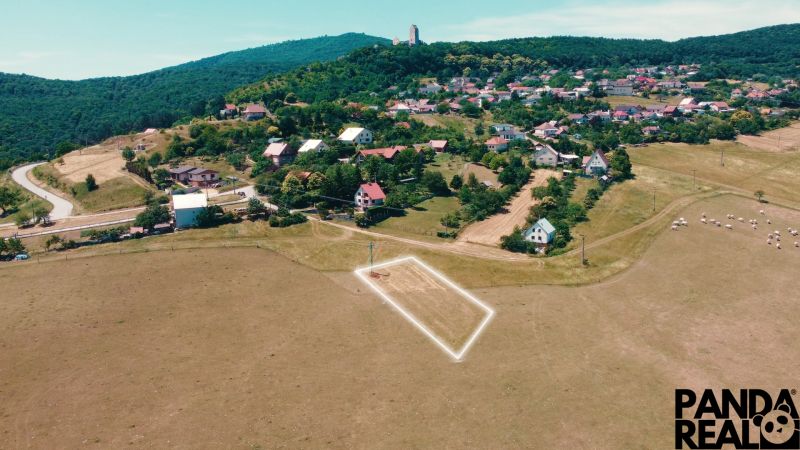 Picturesque landscape of Podhradie, residential plots nestled in green hills.