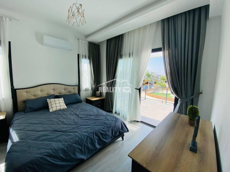 A bedroom in a family house with a large bed and a floor with a wooden decor.