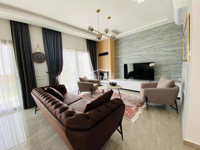 Living room in a family house with a luxurious sofa, carpet, and a large television.