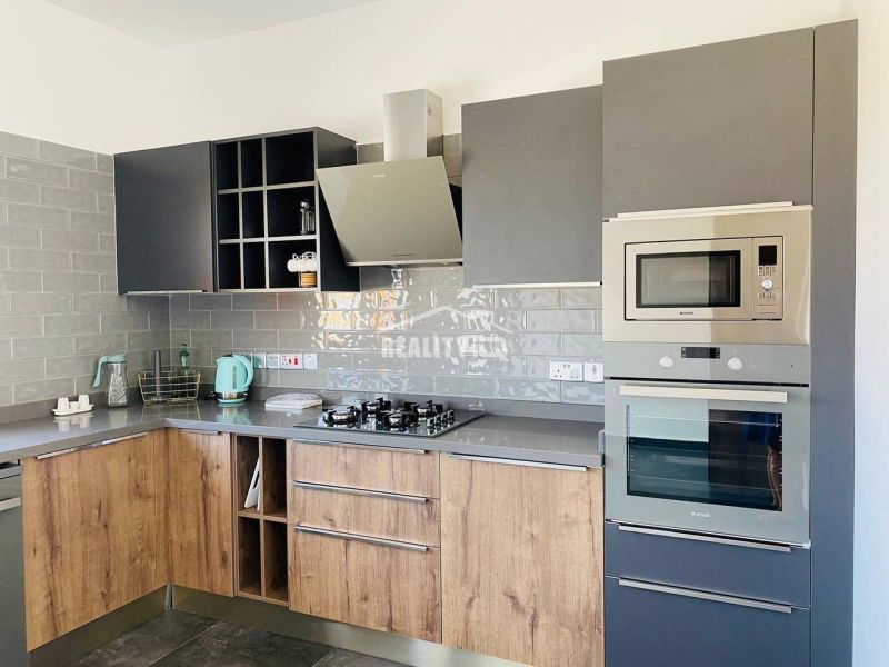 A kitchen with a wooden decor floor and gray cabinets in a family house.
