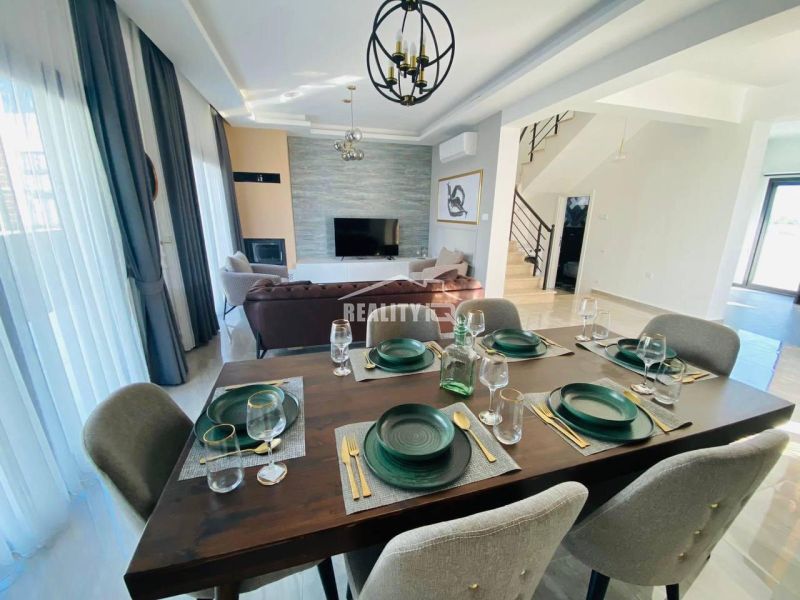 A dining room in a family house with elegant dark furnishings and six chairs.