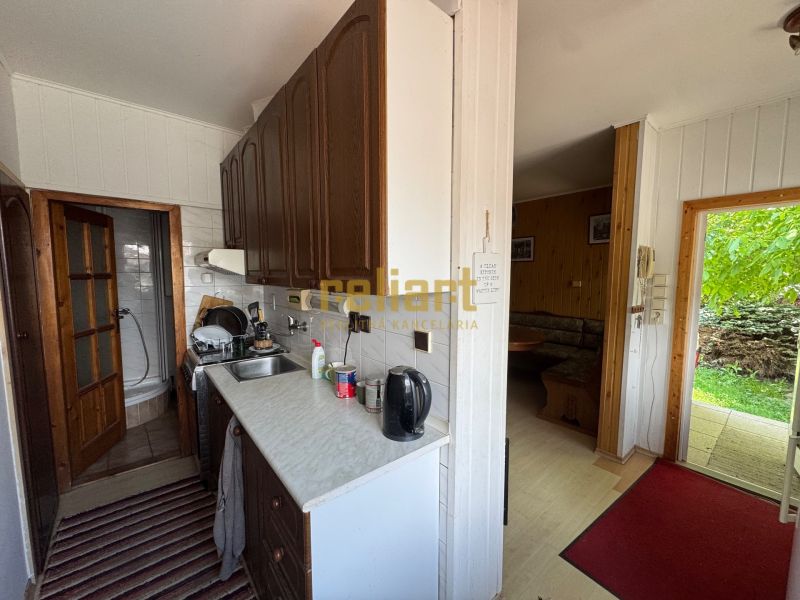 A kitchen in a family house with a bathroom, living room, and a view of the garden.