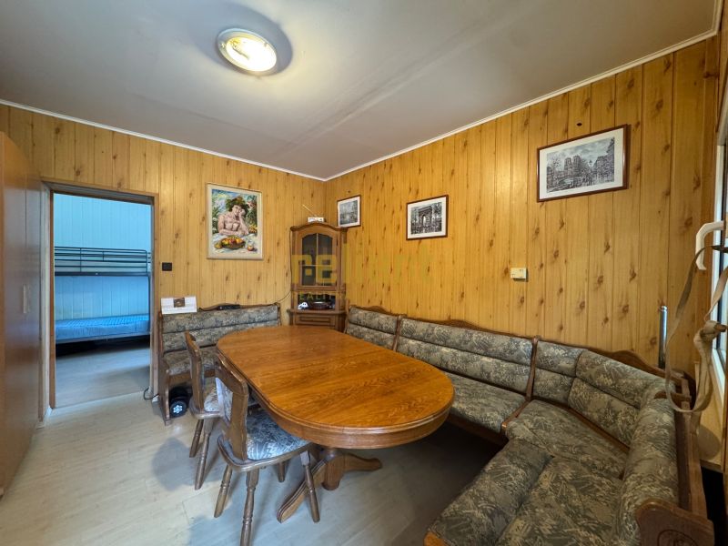 Dining area in a family house with a wooden decor floor and rustic furniture.