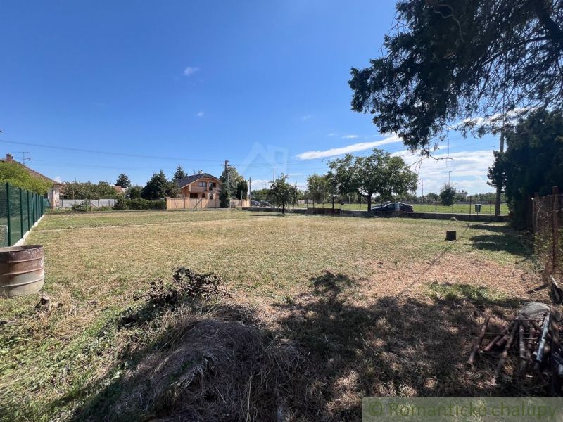 Extensive gardens in Bernolákovo with a lawn, greenery, and blue sky.