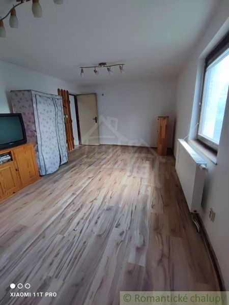 A room in a family house with a television and a wooden decor floor.
