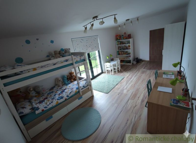 Children's room with a bunk bed, a desk, and a floor with a wooden decor.