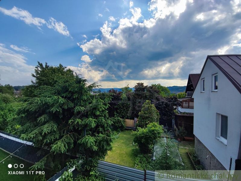 A family house in Banská Bystrica with a large garden, surrounded by greenery and trees.