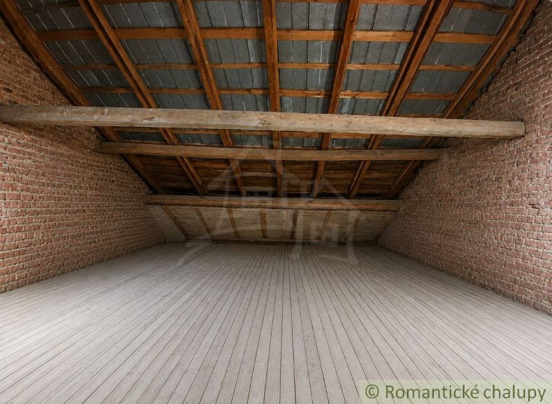 An attic room with wooden beams, brick walls, and a floor with a wooden decor.