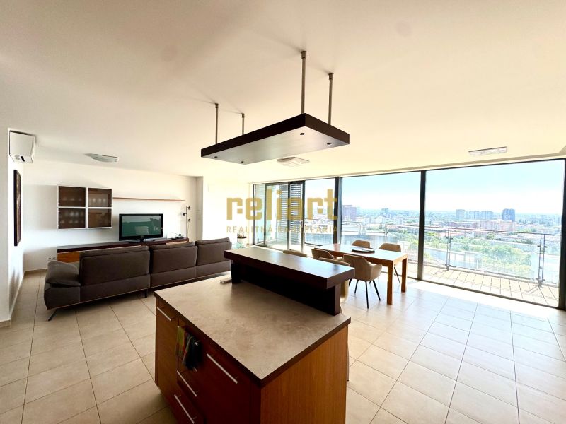 A spacious living area with a kitchen and dining room in a 4-room apartment with a panoramic view.