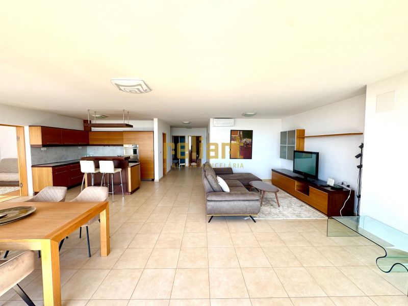A spacious living room in a 4-room apartment with a kitchen, tiles, and comfortable seating.