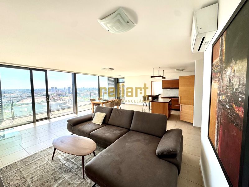 A spacious living area in a 4-room apartment with large windows and a view of the city.