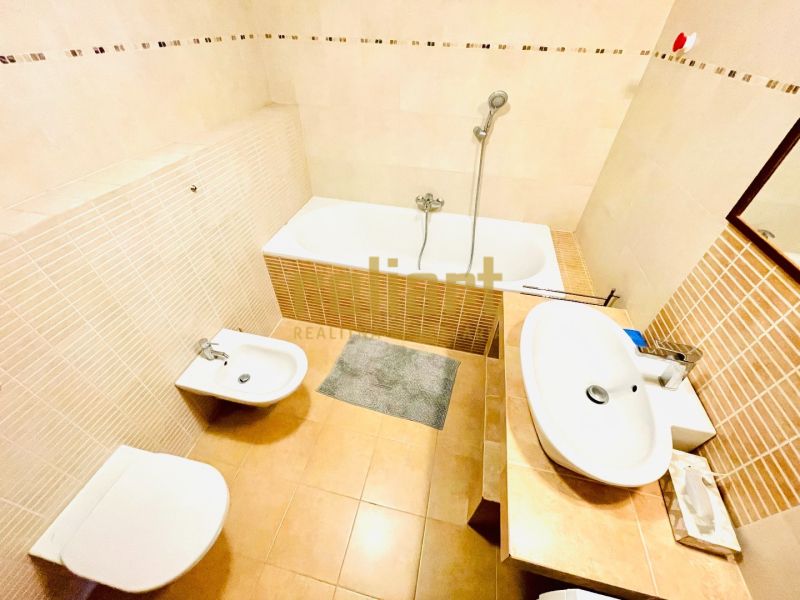 A bathroom in a 4-room apartment with a bathtub, bidet, and sink in light shades.