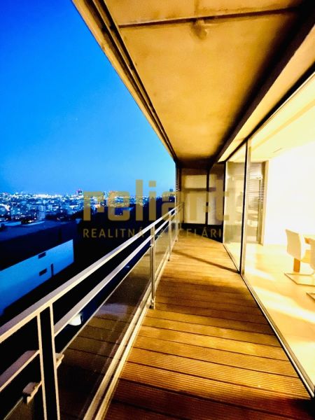 Night view from the balcony of a 4-room apartment with a wooden decor floor.
