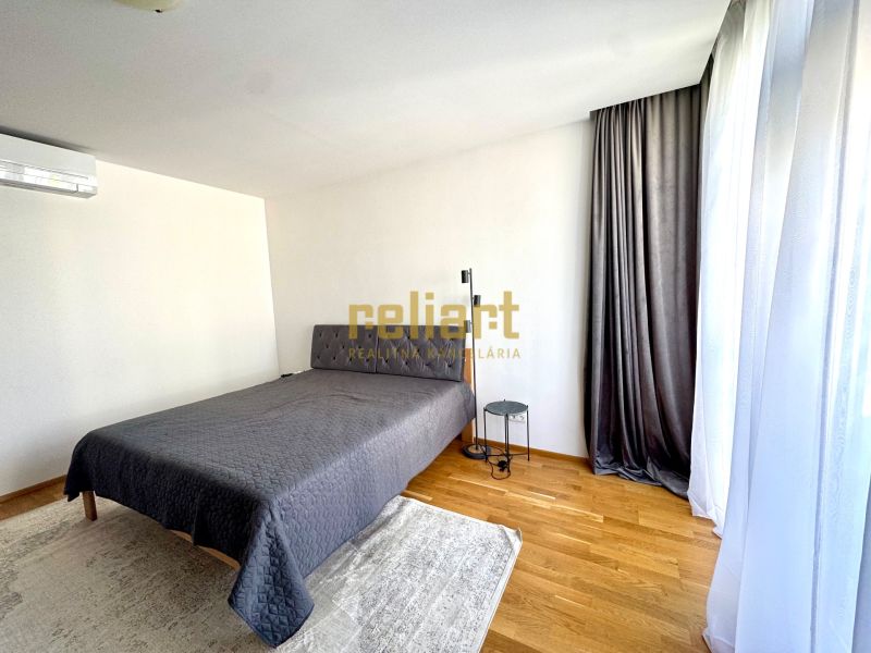 Bedroom in a 4-room apartment with a bed, curtains, and a floor with a wooden decor.