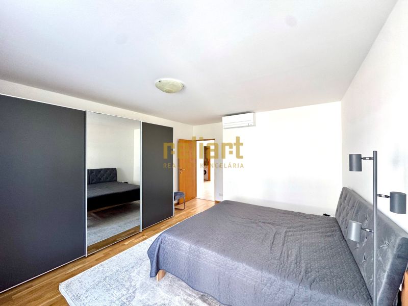 Bedroom in a 4-room apartment with a large wardrobe and a wooden decor floor.