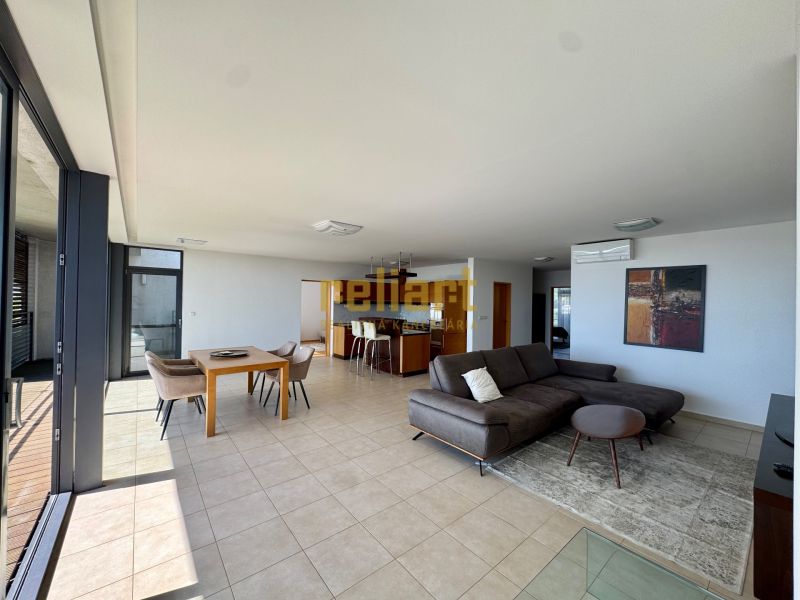 A spacious living room in a 4-room apartment with large windows, a sofa, and a dining table.
