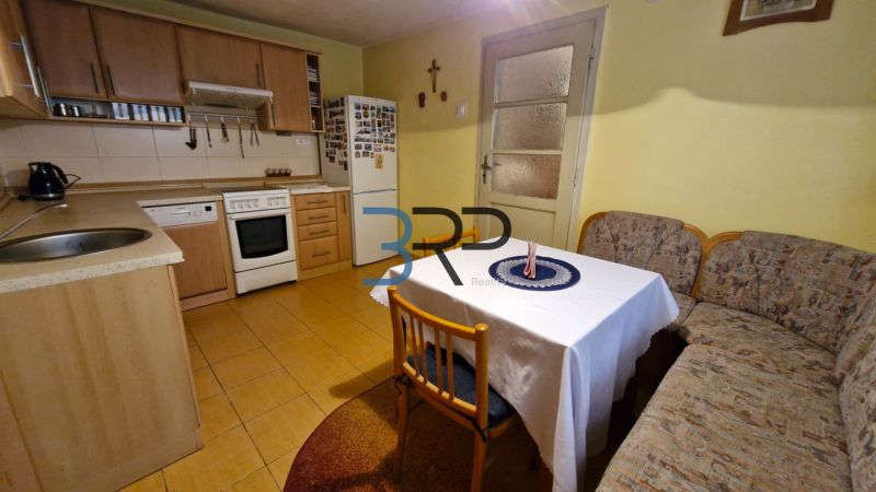A kitchen in a family house with a kitchen unit, a corner bench, and a table with chairs.