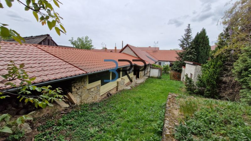 A garden at a family house in Mokré Háj with a stone wall and red roofing.