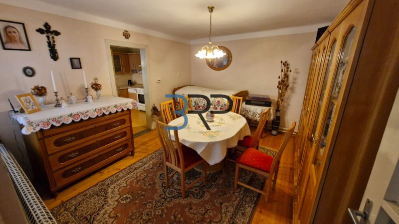 Dining room in a family house with wooden decor, table, and sideboard.
