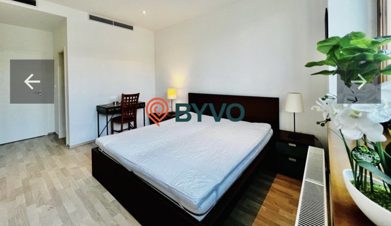 A bedroom with a large bed, a desk, and a wooden decor floor in a 3-room apartment.
