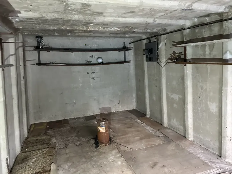 Concrete room with wall mounts and a floor with wood decor in garages.