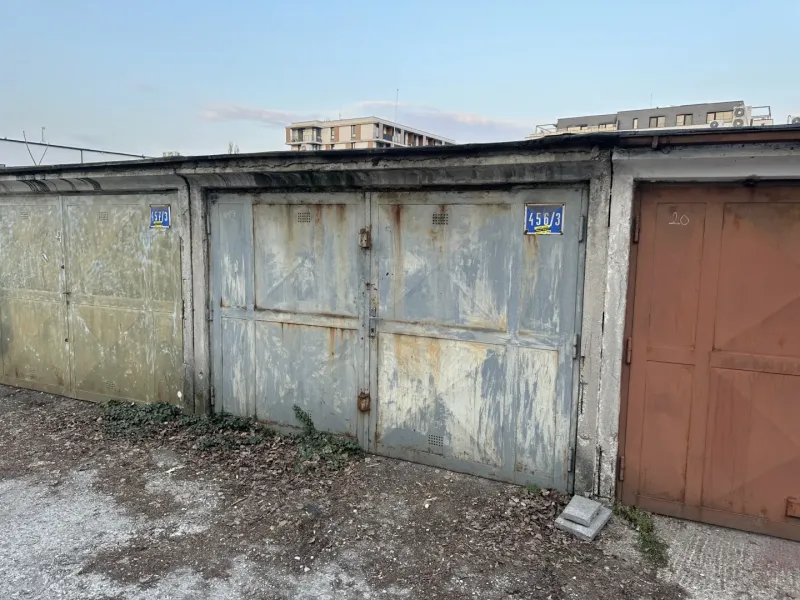Abandoned garages in Bratislava - Nové Mesto with peeling plaster and metal doors.
