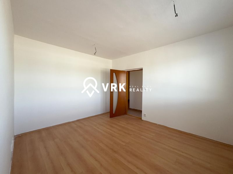 A room in a 2-room apartment with a floor featuring a wood decor and white walls.