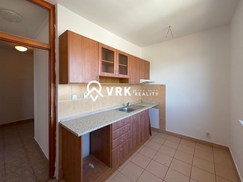 A kitchen in a 2-room apartment with a kitchen unit and tiled floor.